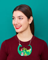 Jolly Granny Dino-Claus reading to her Grand-Elf-Dinos Necklace